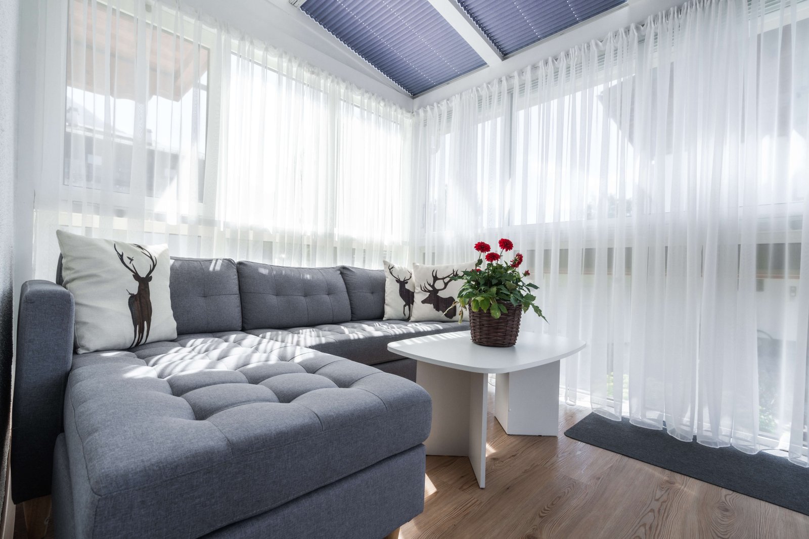 Heller Wintergarten mit Sofa und Zugang zur Sonnenterrasse