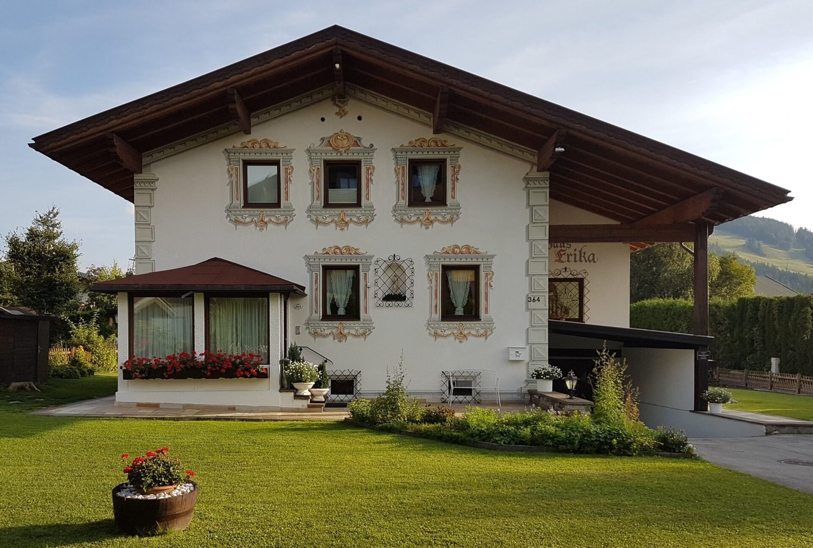 Casa Erika con la facciata tirolese dipinta e il giardino curato
