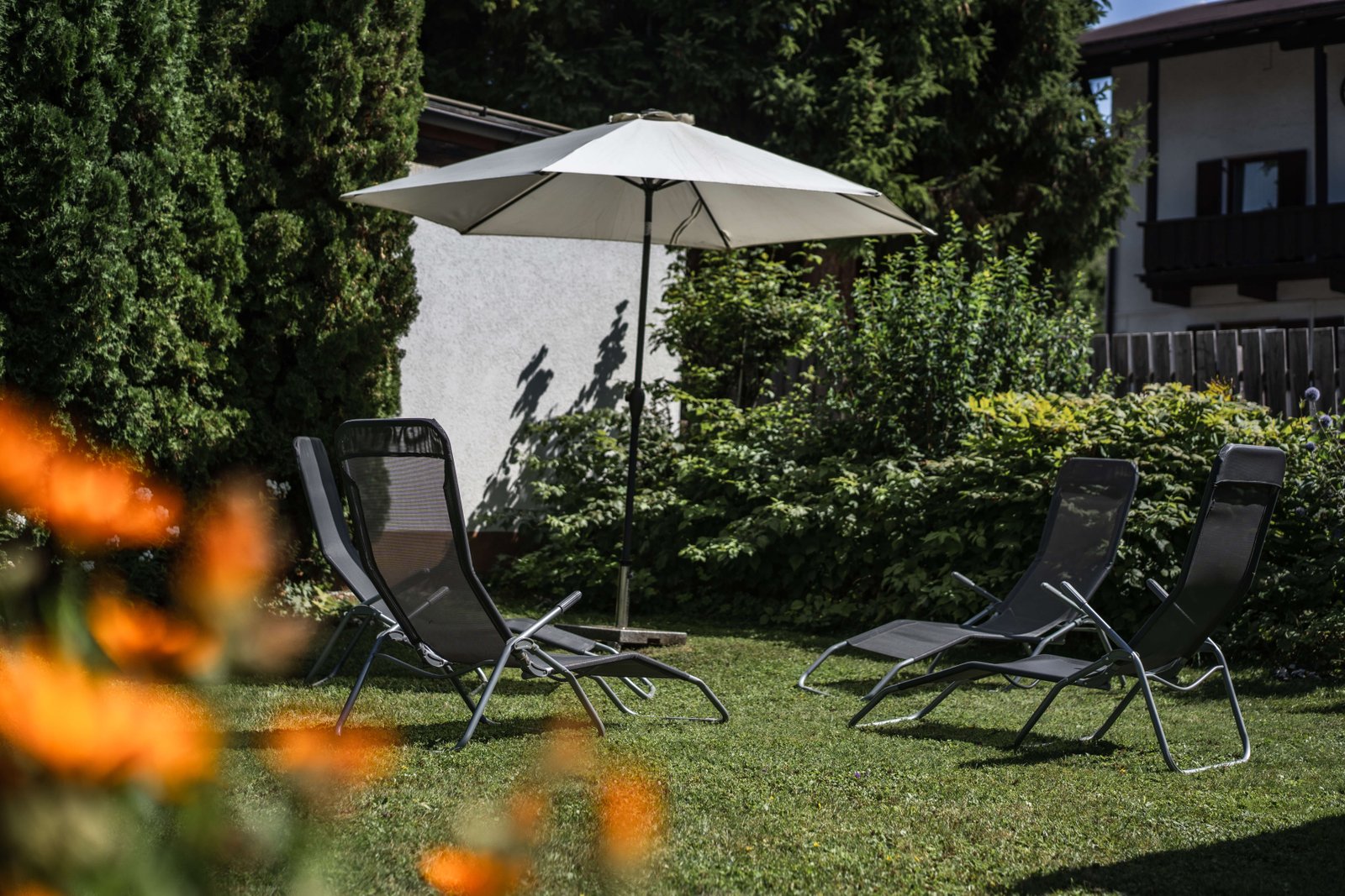 Garten mit Liegestühlen und Sonnenschirm